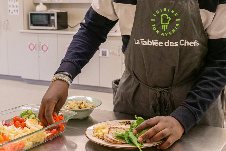 main d'un jeune dressant une assiette