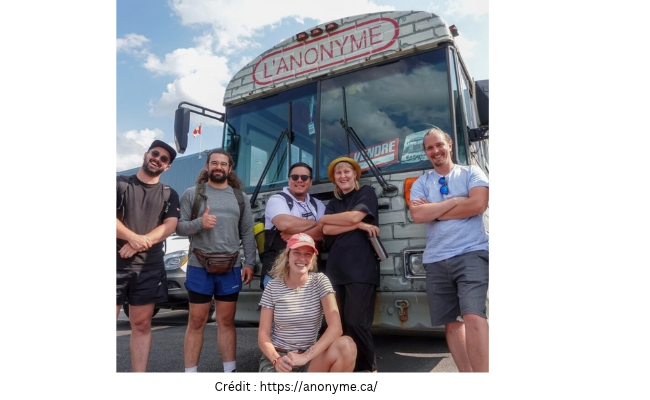 photo d'un groupe de personnes qui posent devant l'autobus de L’Anonyme